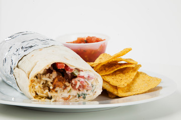 Plate of meat wrap and nachos with sauce over white background