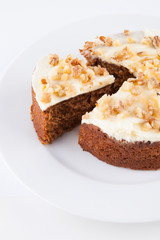 Close-up of walnut cake in plate over white background