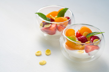 Vitamin dessert of fresh strawberries, apricots and cornflakes with cream