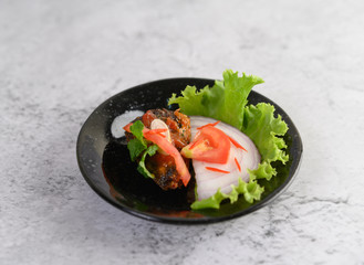 Appetizing Spicy Canned Sardine salad in spicy sauce in black ceramic bowl