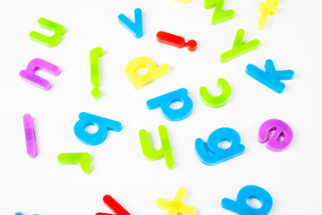 Colorful alphabet magnets scattered over white background