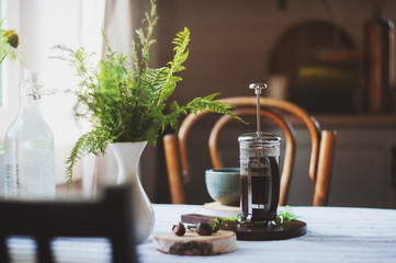 summer morning at wooden cottage kitchen with coffee and wild ferns in vase