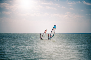 Romance in the sea couple man and woman together sailing on a windsurfing board while on vacation in south