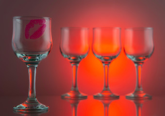 Red lipstick kiss on one glass of four