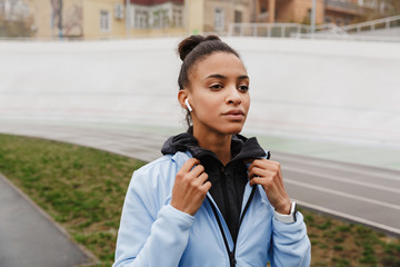 Attractive young healthy african sportswoman listening to music