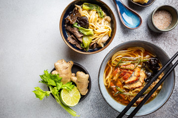Set of Serving Asian Soups on gray background top view. Tom Yum Soup, Eel Fish Soup and Ramen noodle Soup
