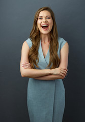 Happy woman with crossed arms, long hair and toothy smile.