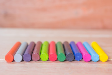 Naklejka premium Colorful pastel crayons on wooden background