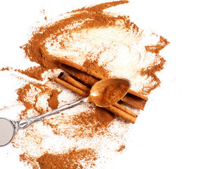 Cinnamon powder and cinnamon sticks on a light background
