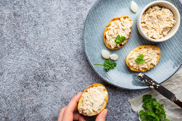 Sandwiches with salmon pate and baguette, fish bruschetta, top view. Rustic homemade Italian cuisine.
