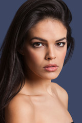 Fototapeta premium Close-up portrait of beautiful young woman over blue background