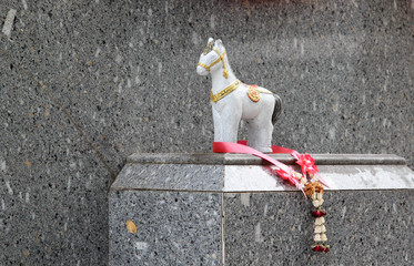 The white horse statue and flower garland.
