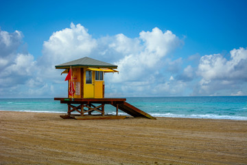 Miami South Beach dawns with lifeguard tower and coast with colorful clouds and blue sky.