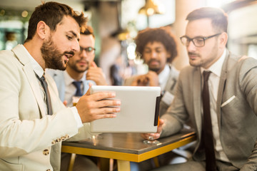 It's lucky to do the job you love. Four businessman siting in the cafe and they talk business
