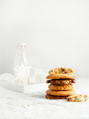 Selection of homemade cookies, milk, winter decor on white background