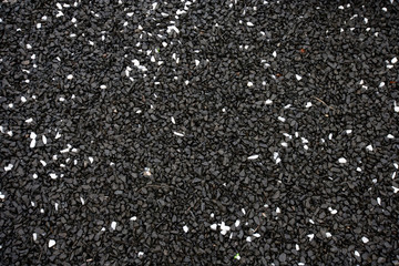 Wet black gravel with some white pebbles