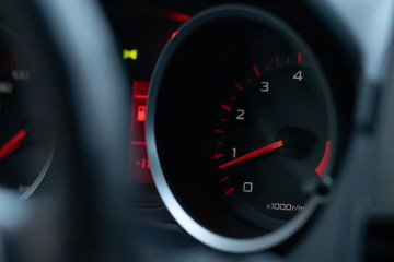 Car tachometer close-up. The arrow indicates low engine speeds.