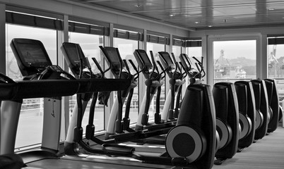 Staying fit with cardio elliptical  fitness equipment trainer and treadmills in gym or fitness...