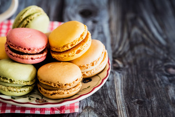 Assortiment de biscuits macarons colorés sur une soucoupe vintage