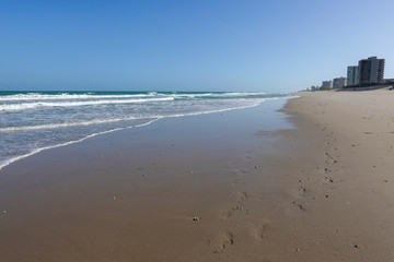 Footprints in the sand on an Atlantic Ocean coastline beach