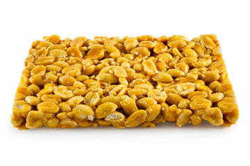 Brittle of peanuts on a white background. Sweet candy made of caramel and nuts. Healthy sweets made from natural ingredients