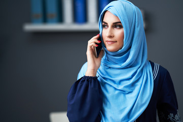 Muslim adult woman using smartphone