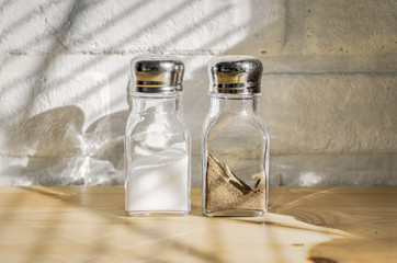 Transparent glass saltcellars with salt and pepper