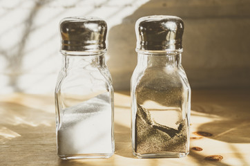 Transparent glass saltcellars with salt and pepper