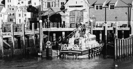 Whitby, North Yorkshire, England - Jan 28, 2019:,UK - Black and white photo  of The harbour at Whitby on the North Yorkshire coast, Fishing boats tied up to the quay in Whitby harbour