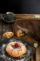 rundes gebäckstück mit schokoladenfüllung, himbeere, zuckerstreusel und einer tasse kaffee