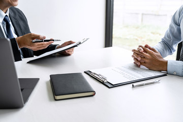 Senior committee manager reading a resume during a job interview, Employer interviewing to ask young male job seeker for recruitment talking in office
