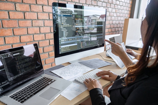 Two professional programmer cooperating and working on web site project in a software developing on desktop computer at company, codes and typing data code, Programming with HTML, PHP and javascript
