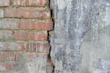 Part of a brick wall subject to aging, divided in half by a crack. Fault, structure.