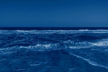 Store enrouleur Vagues de l'océan Color of the year 2020 classic blue. Stormy sea and classic blue sky in summer sunny day. Beautiful natural background with space for text. Fashionable pantone color trend concept  © Tatyana_Andreyeva
