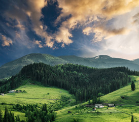 Scenic mountain landscape, summer green meadow at sunset