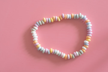 sweets Beads and bracelets candy on a pink background
