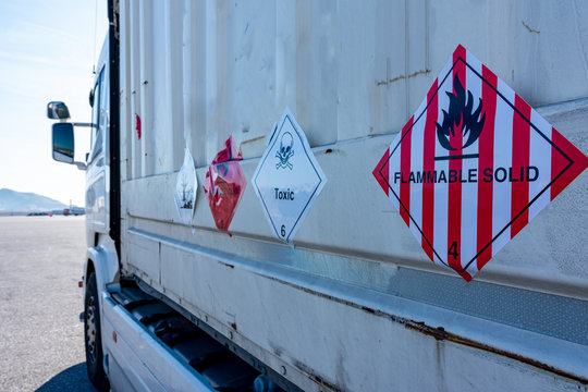 Camion de mercancias peligrosas con etiquetas de peligro por producto inflamable y toxico