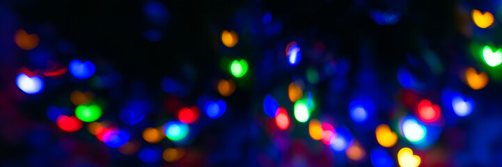 Banner of abstract blur pattern of blue, green, red, yellow lights on isolated black background. Glitter texture of Valentines Day backdrop. New Year light.