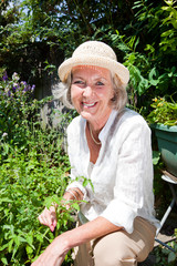 Portrait of happy senior woman gardening in backyard