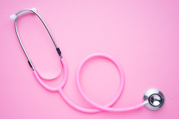 Fototapeta premium Women in the healthcare industy concept. A pink strethoscope on a pink background.