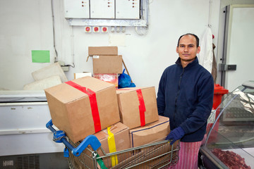 Portrait of male worker with shopping cart in store