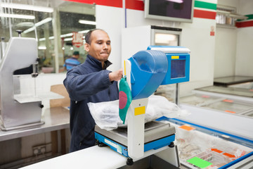 Employee weighing product in supermarket