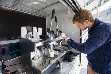 Side view of man working at mobile coffee shop