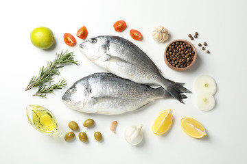 Fresh Dorado fishes, spices and cooking ingredients on white background, top view