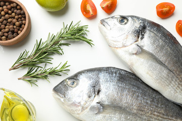 Fresh Dorado fishes and cooking ingredients on white background, top view