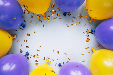 balloons and confetti on blue table top view. Festive or party background. Flat lay style. Copy...