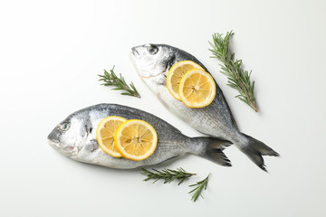 Fresh Dorado fishes, lemon and rosemary on white background, top view