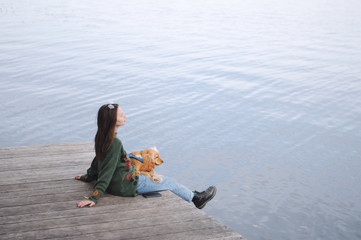 Girl and english cocker spaniel dog lying on wooden bridge.Portrait of dog outside (outdoors)....