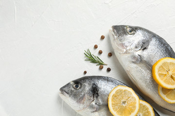 Fresh Dorado fishes, pepper, lemon and rosemary on white background, close up