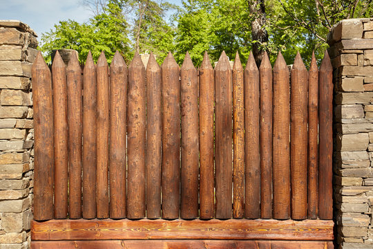 A wooden fence made of pointed logs